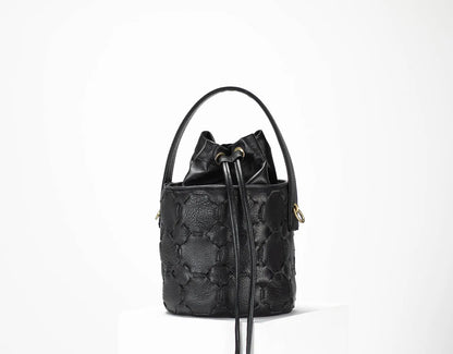Black quilted handbag on a white background
