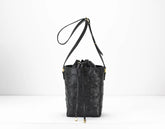 Black textured bucket bag with a drawstring on a white background