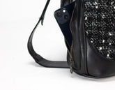 Black handbag with a textured pattern on a white background