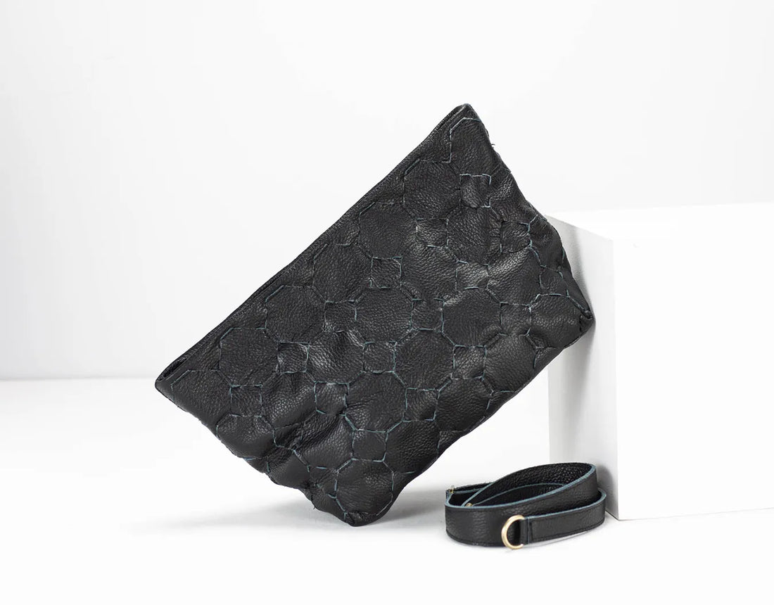 Black textured clutch bag with a matching belt on a white background