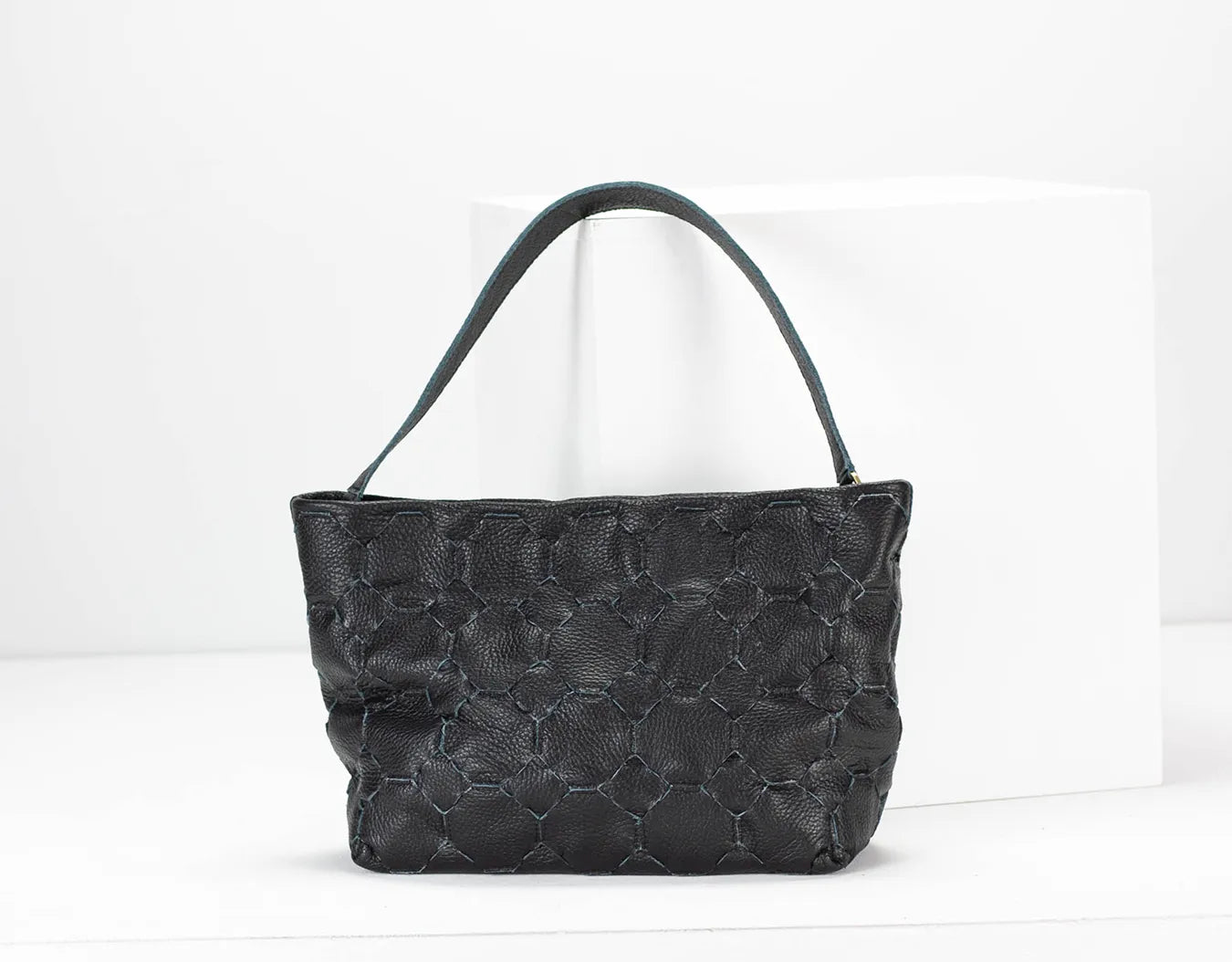 Black textured handbag on a white background