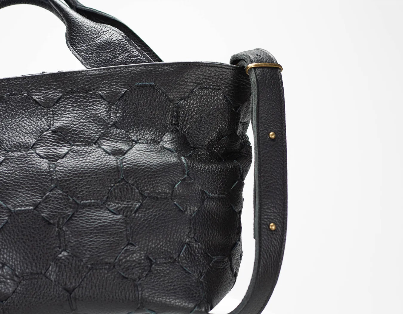 Black textured handbag with a strap on a white background