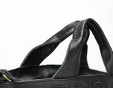 Close-up of a black bag with a strap on a white background