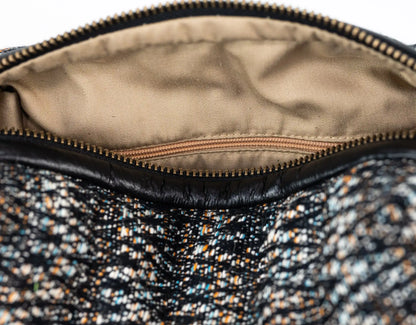 Close-up of a textured fabric interior of a bag with a zipper.