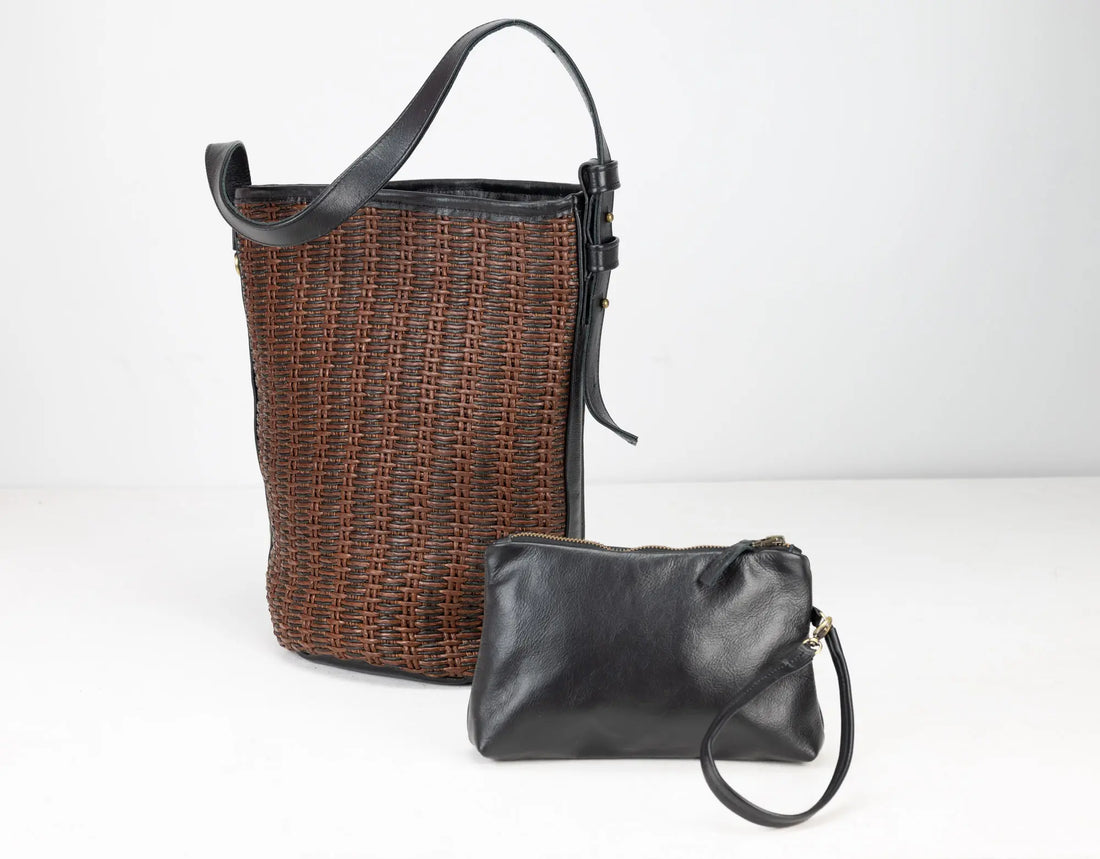 Woven basket and black leather clutch on a white background