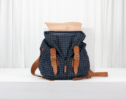 Blue patterned backpack with brown straps on a white background