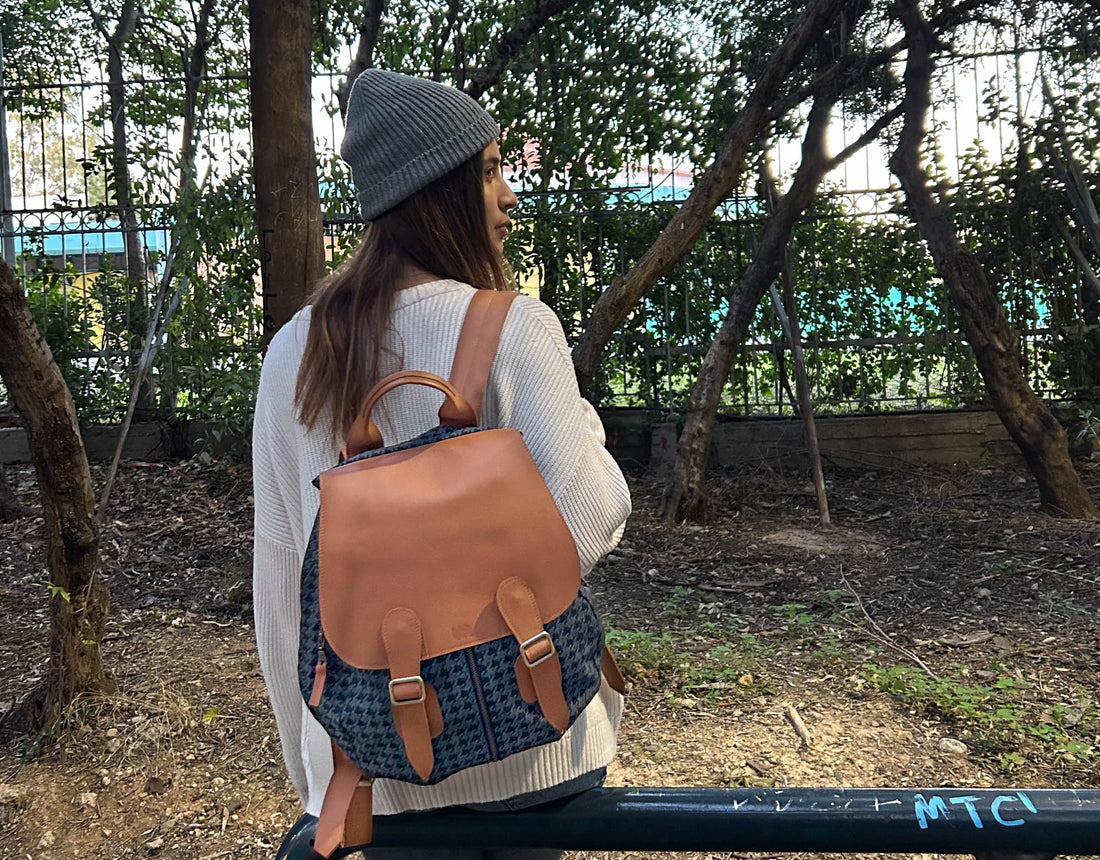 Person wearing a brown leather backpack and gray beanie in an outdoor setting