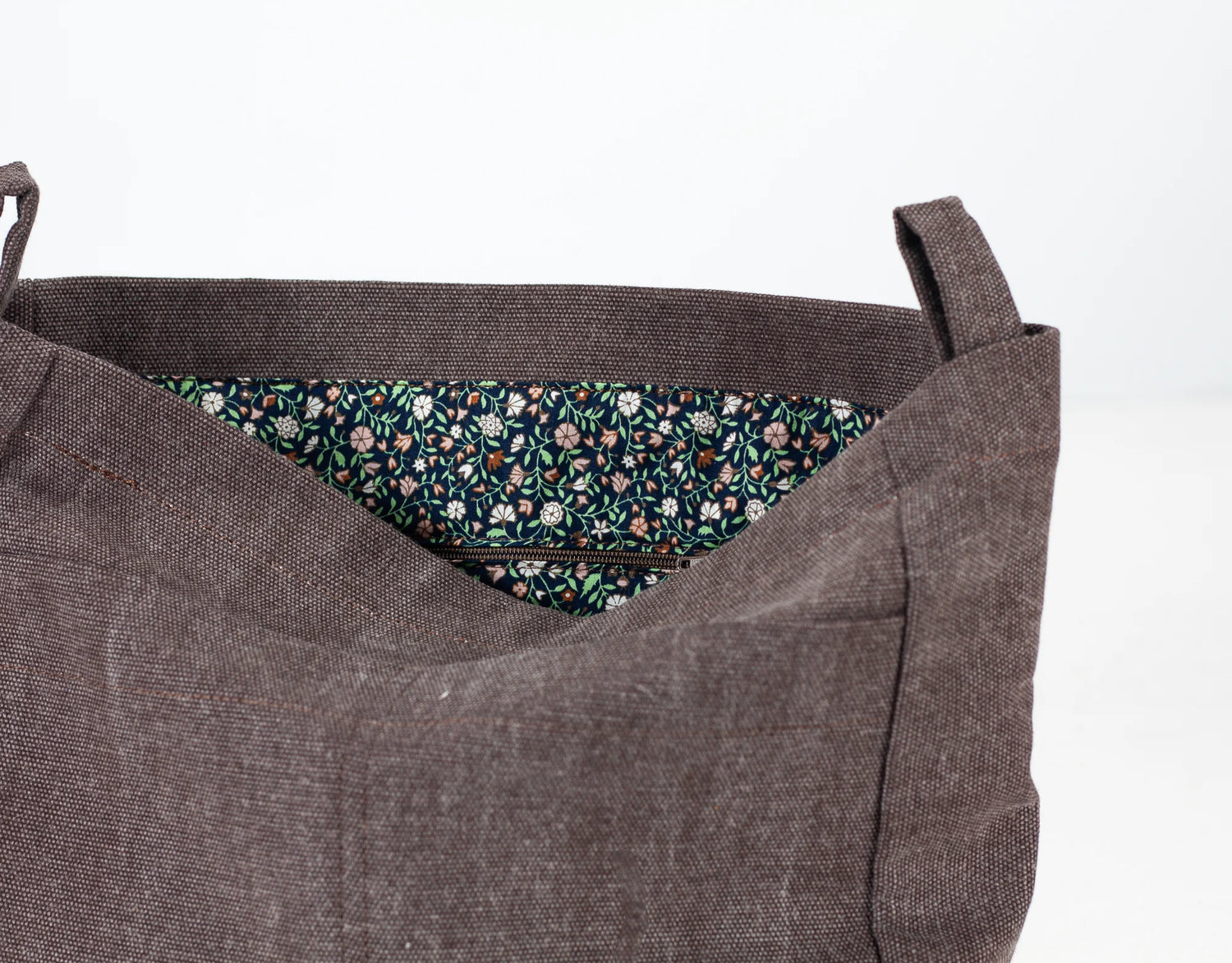Brown fabric bag with floral lining on a white background