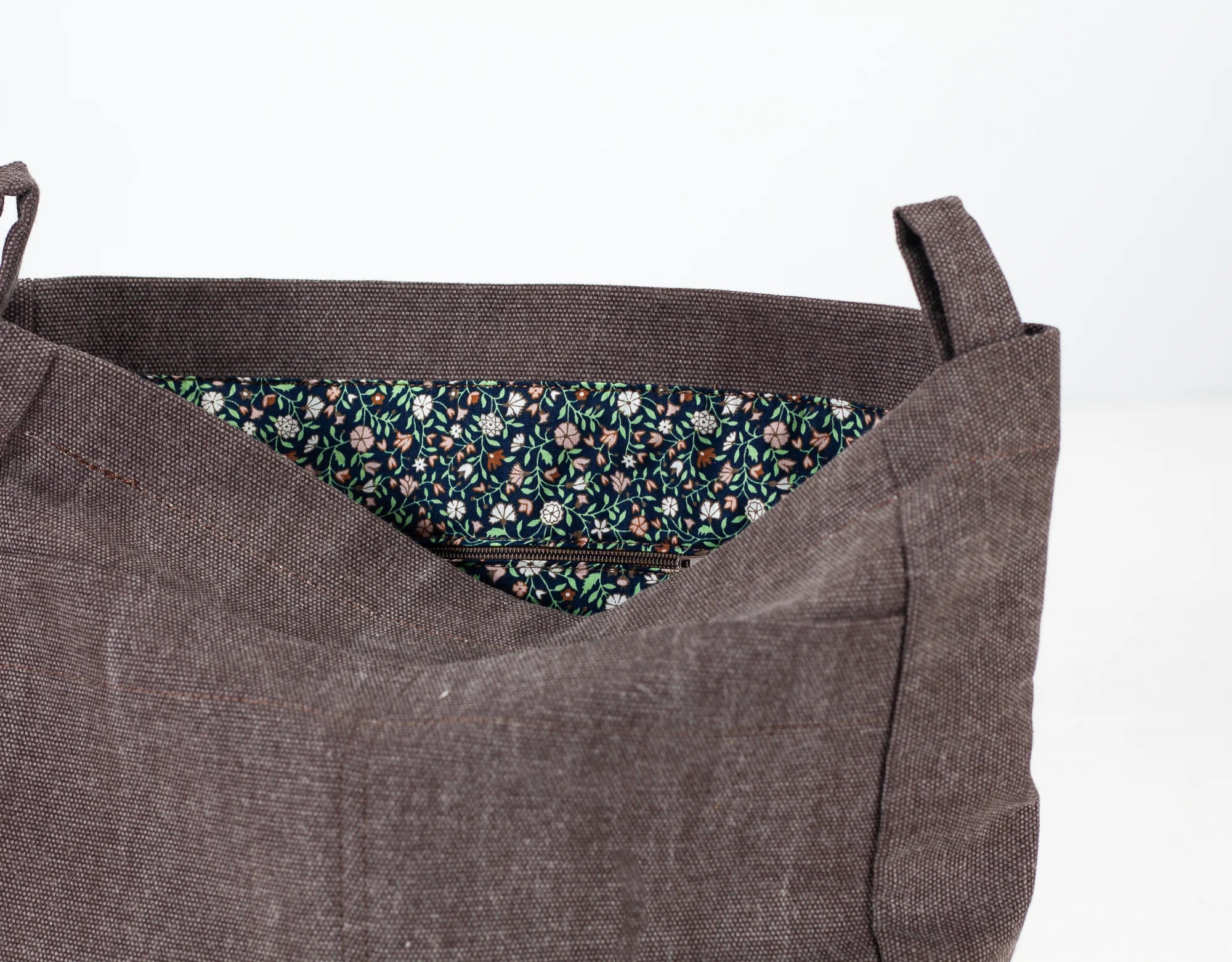 Brown fabric bag with floral lining on a white background