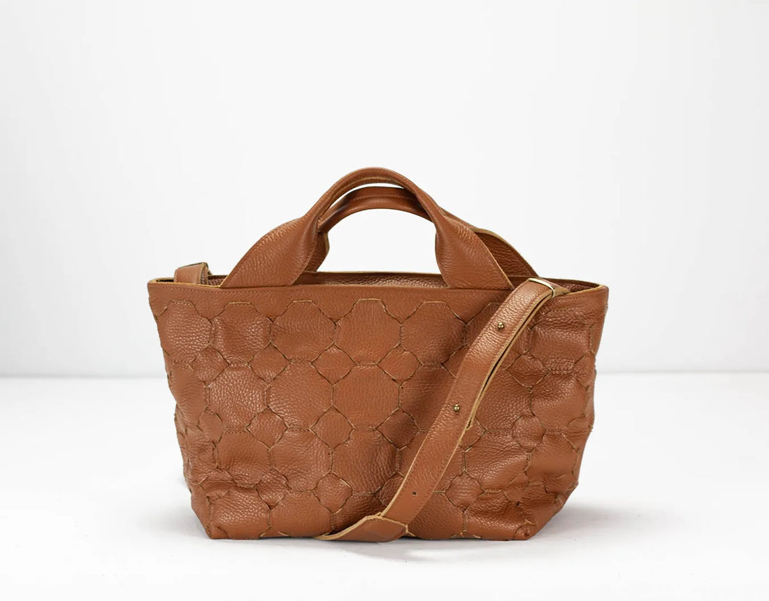 Brown textured handbag with a shoulder strap on a white background