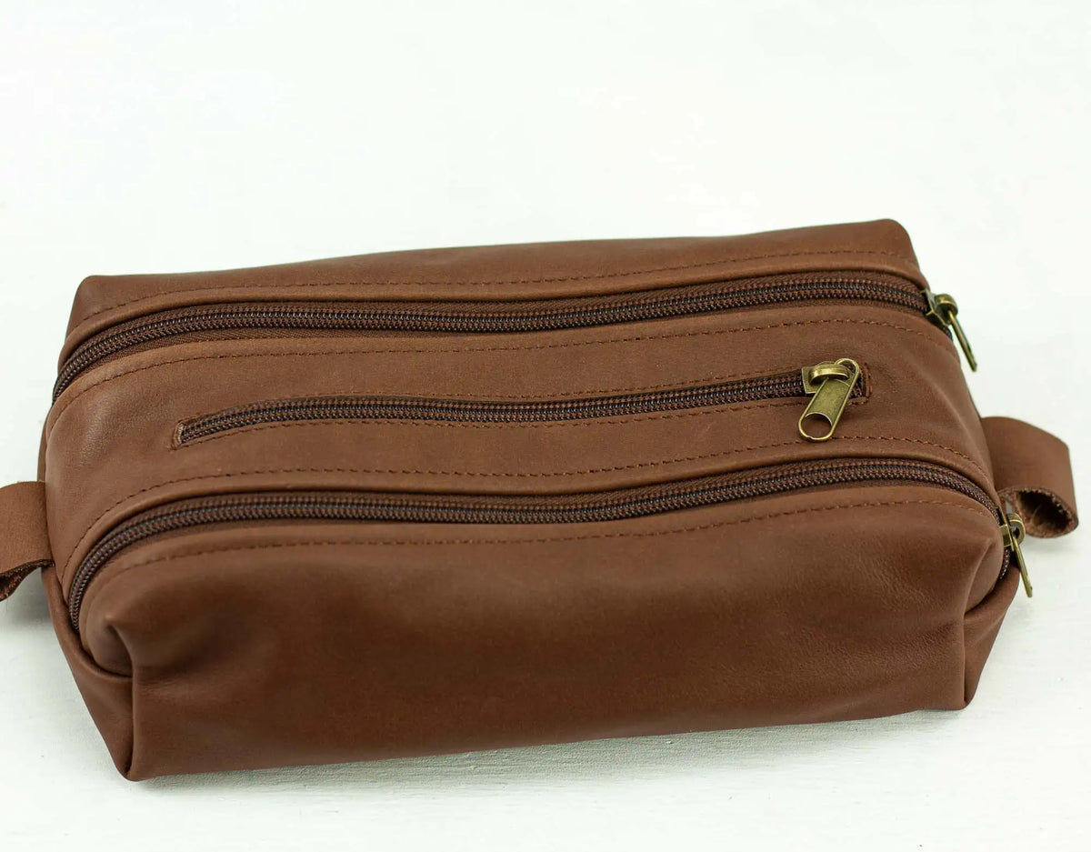 Brown leather toiletry bag with multiple zippers#color_chocolate-brown