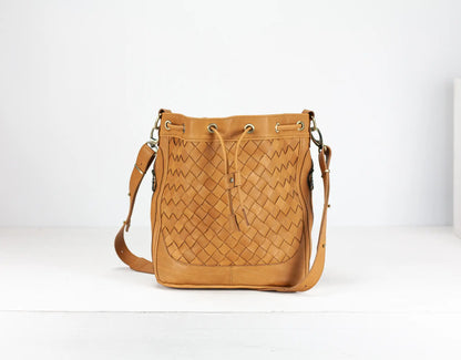 Tan woven leather bag on a white background