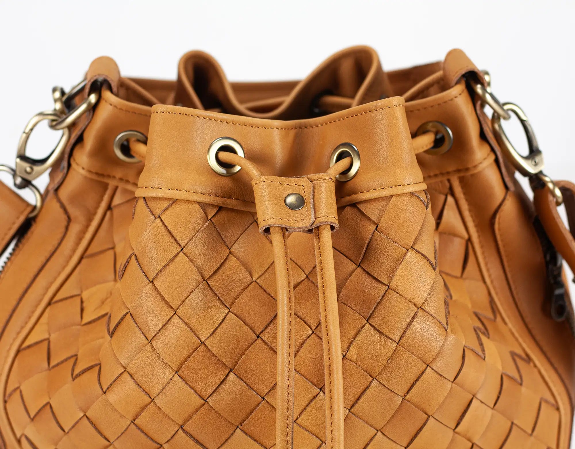 Brown woven handbag with drawstring on a white background