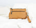 Tan leather handbag with multiple zippers on a white background