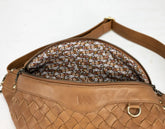 Brown woven handbag with a floral patterned interior on a white background