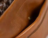 Close-up of a brown leather bag with visible stitching