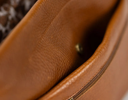 Close-up of a brown leather bag with visible stitching