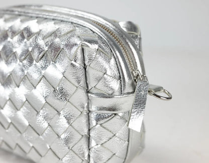 Silver woven clutch bag on a light gray background