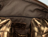 Close-up of a brown leather bag with a visible brand label.