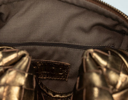 Close-up of a brown leather bag with a visible brand label.