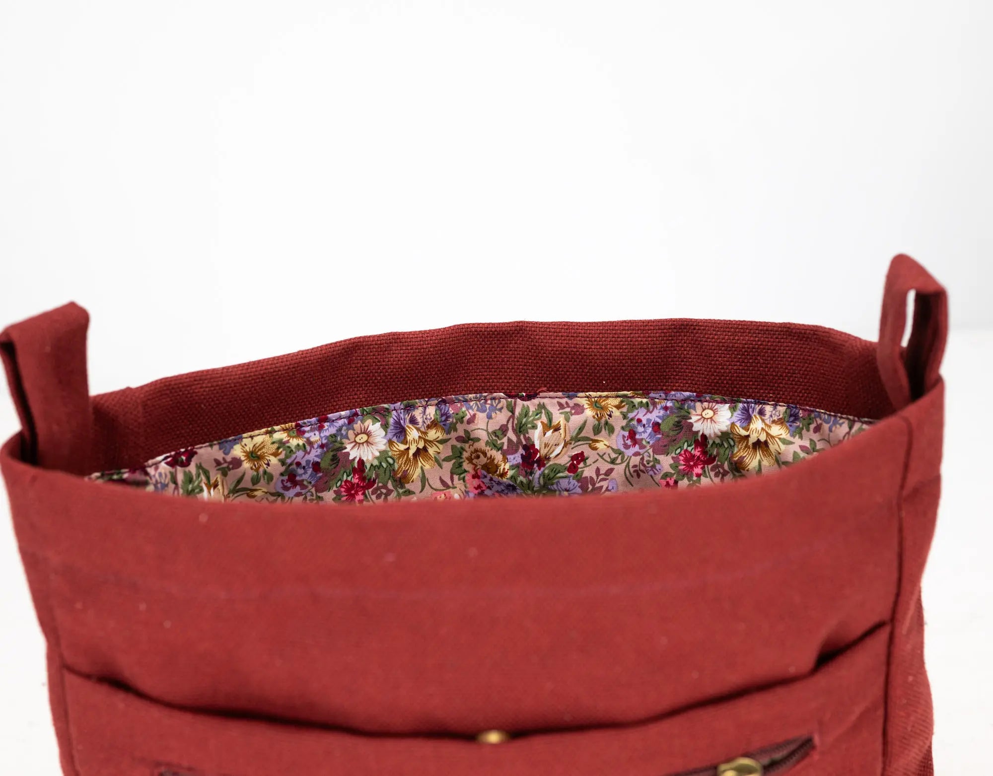 Red fabric basket with floral lining on a white background