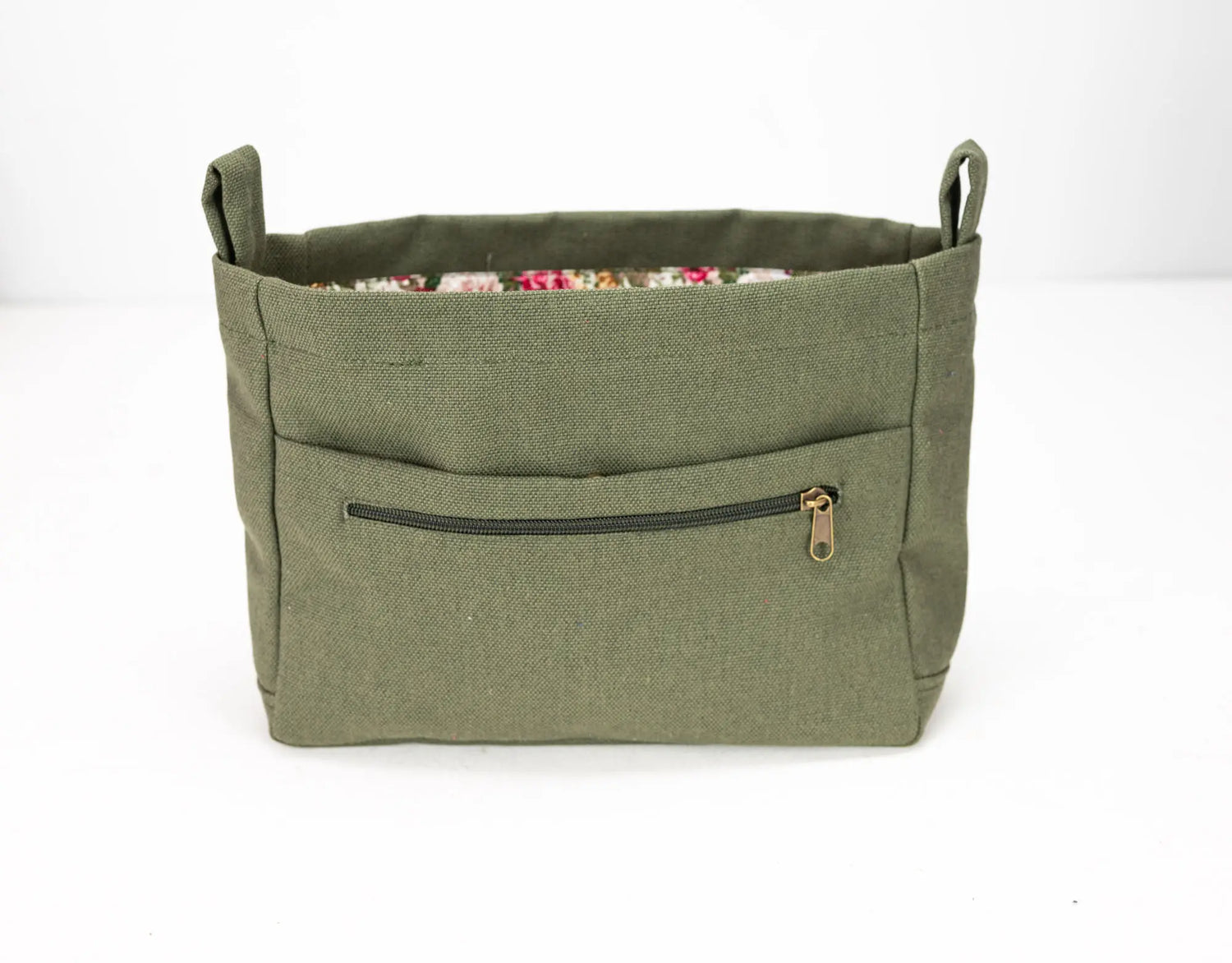 Green fabric bag with a zipper pocket on a white background