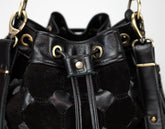 Black leather handbag with gold hardware on a white background