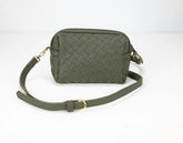 Green woven handbag with a strap on a white background