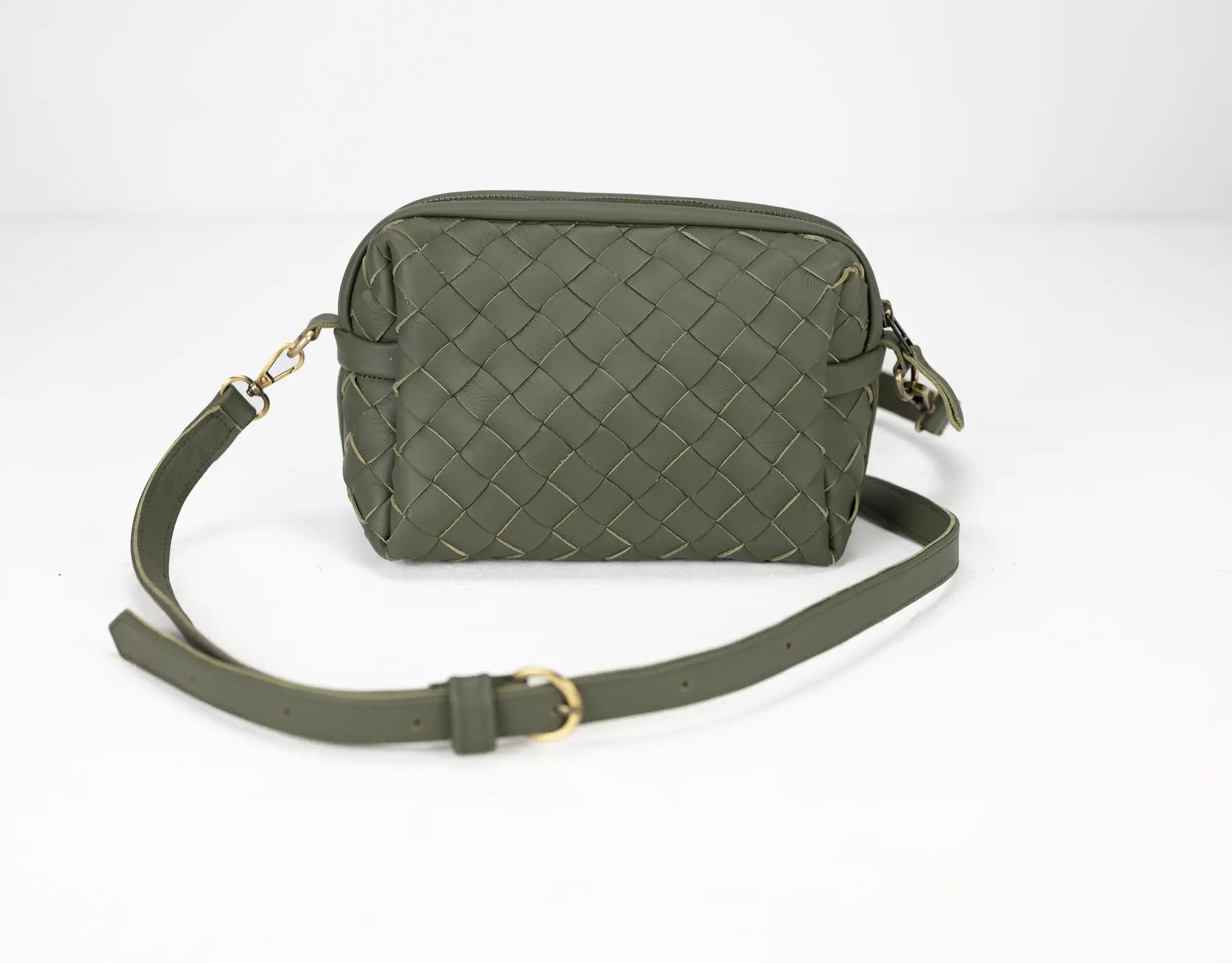 Green woven handbag with a strap on a white background