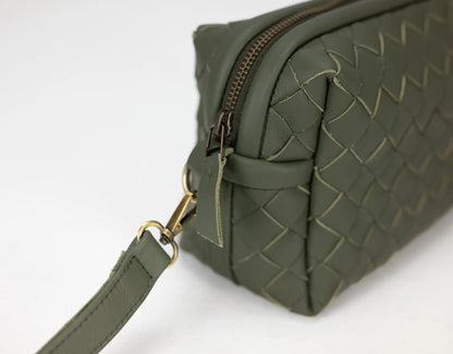 Green woven handbag with a gold zipper on a white background