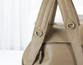 Beige handbag with gold hardware on a light background