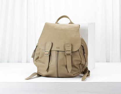 Beige backpack on a white surface with a light background