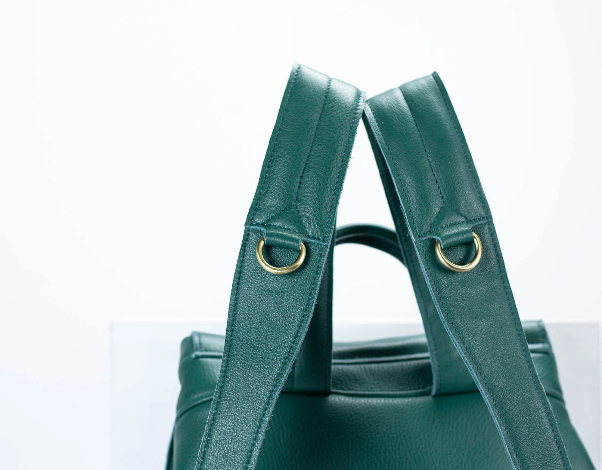 Green handbag with gold hardware on a white background