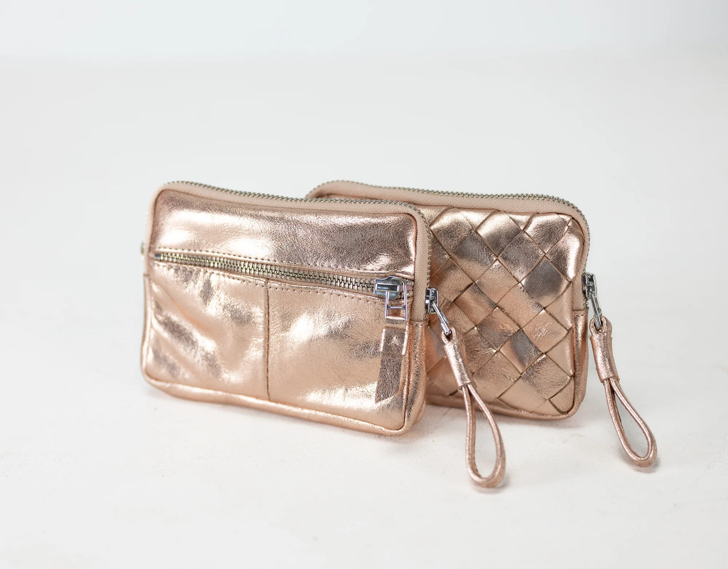 Rose gold clutch bag with woven pattern on a light gray background