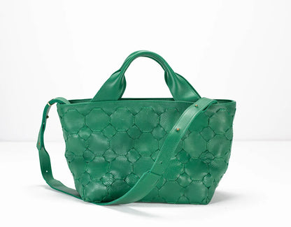 Green quilted handbag on a white background