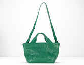Green quilted handbag on a white background