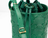 Green woven bucket bag with a strap on a white background