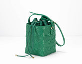 Green quilted handbag on a white background