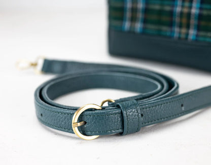 Teal leather belt with gold buckle on a white background