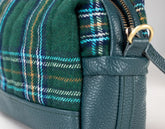 Green plaid bag with leather accents on a light gray background