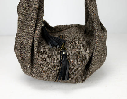 Brown textured handbag with a black zipper on a white background