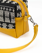Yellow handbag with black and white patterned top section 
