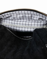 Close-up of a black textured bag with a zipper, showing the interior lining.