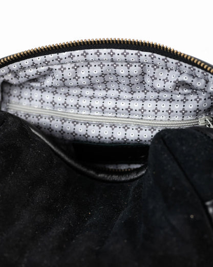 Close-up of a black textured bag with a zipper, showing the interior lining.