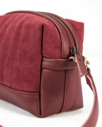 Close-up of a red handbag with a gold zipper on a white background