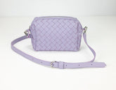 Lavender quilted handbag with a strap on a white background