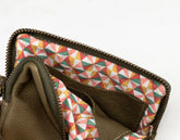 Brown leather wallet with geometric patterned interior on a white background