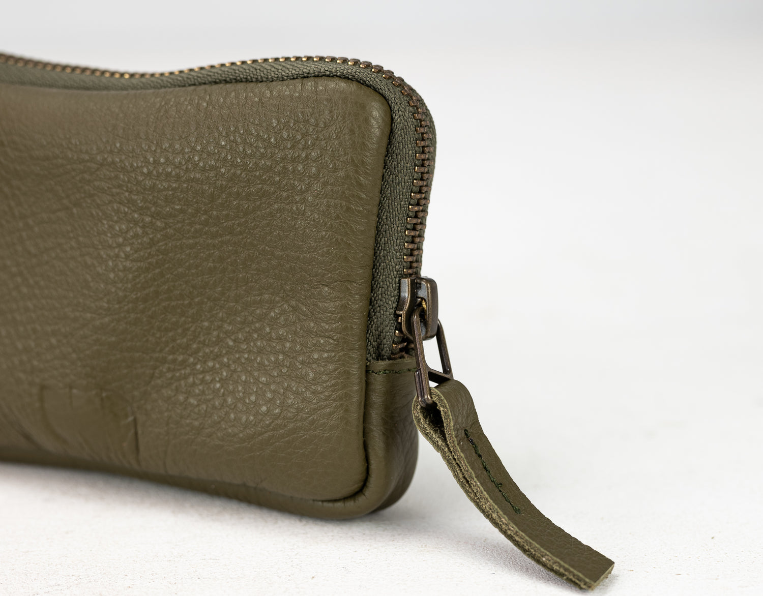 Green leather wallet with a zipper on a white background