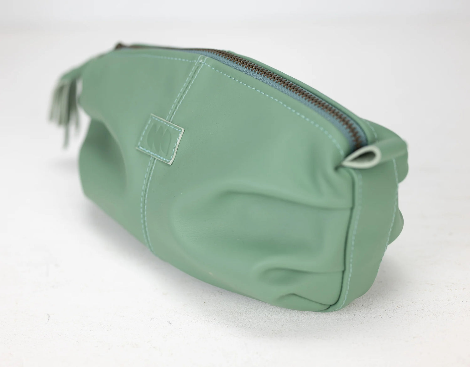 Green toiletry bag with a zipper on a white background