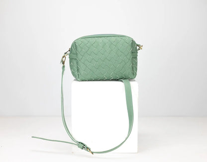 Green quilted handbag with a strap on a white background